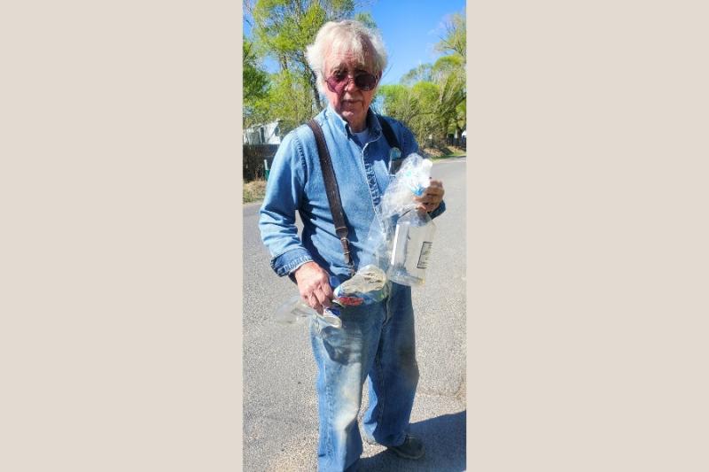 Man holding a few pieces of trash.