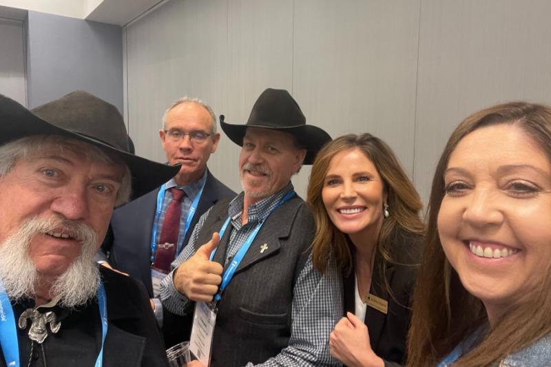 Five individuals smiling for a group selfie.