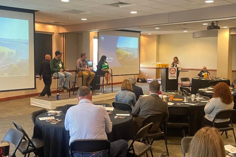 A woman (Bobbie Daniel, Mesa County Commissioner) giving a speech at a conference. 