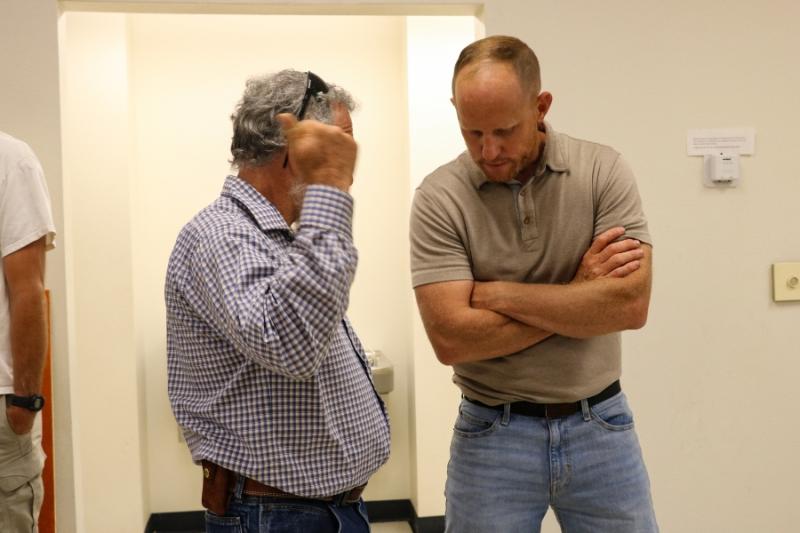 Two men speaking to each other.
