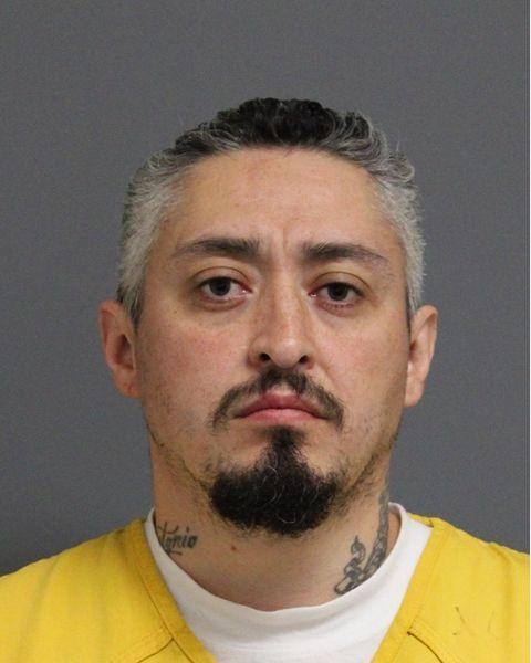 Inmate photo of Devin Atencio wearing a yellow jumpsuit. 