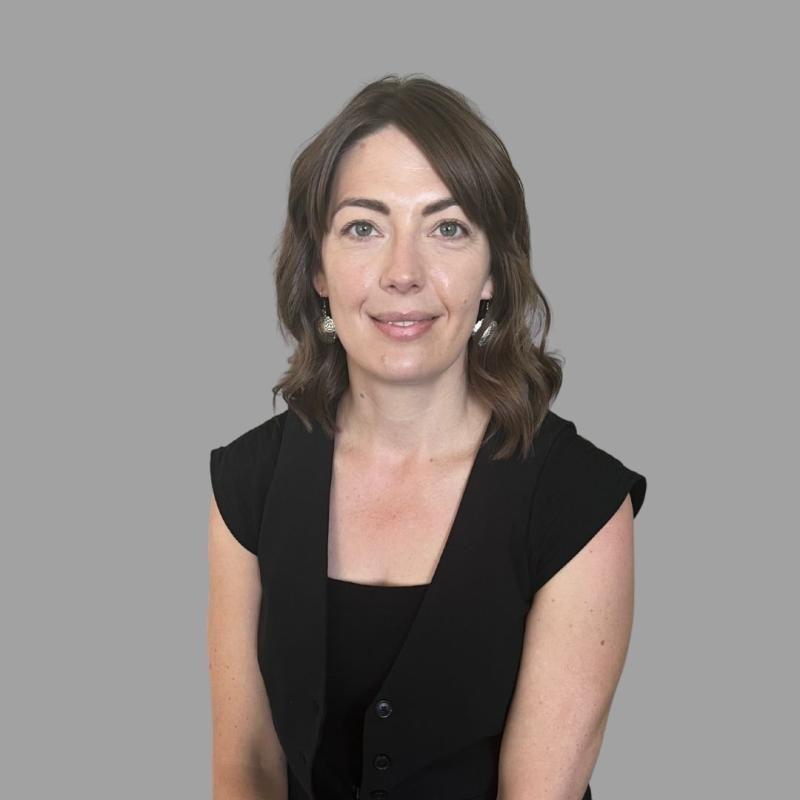 Professional woman with shoulder length hair in a black, short-sleeve shirt.