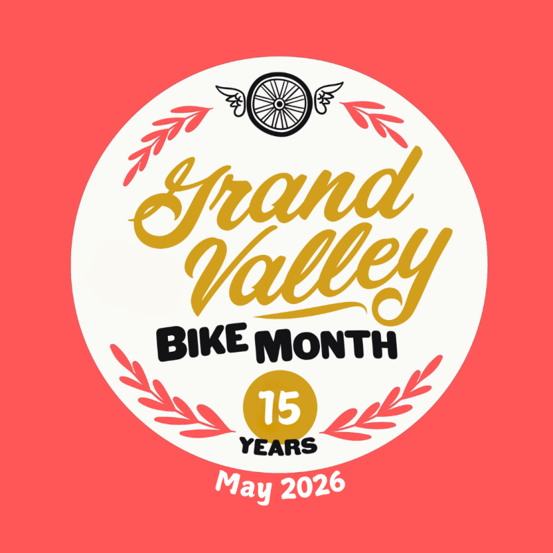 Peach background with the words Grand Valley Bike Month 15 Years May 2026 written in a circle with a flying wheel