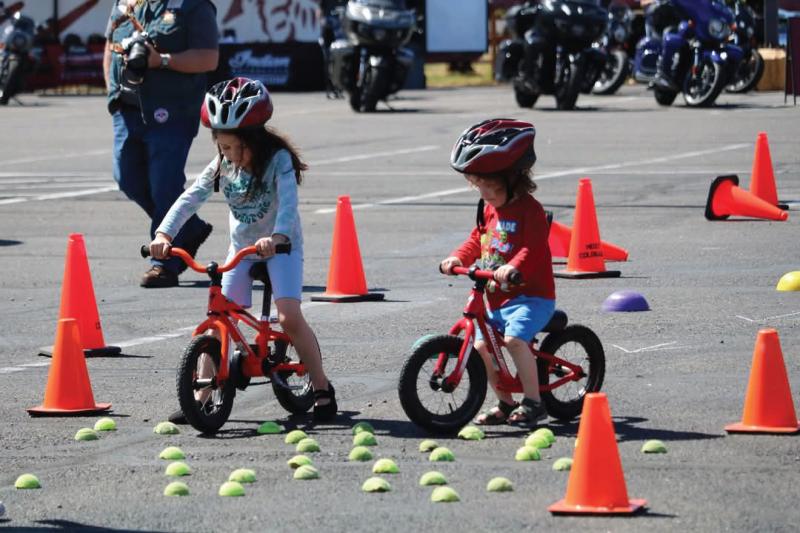 Two young kids on a bicycle at Cycle Safety Fest 2025
