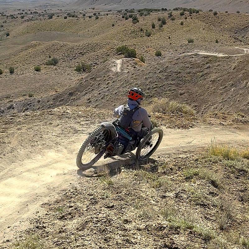 This person is biking a trail at North Fruita Desert using a specially modified electric motor assisted tricycle called an adaptive mountain bike.