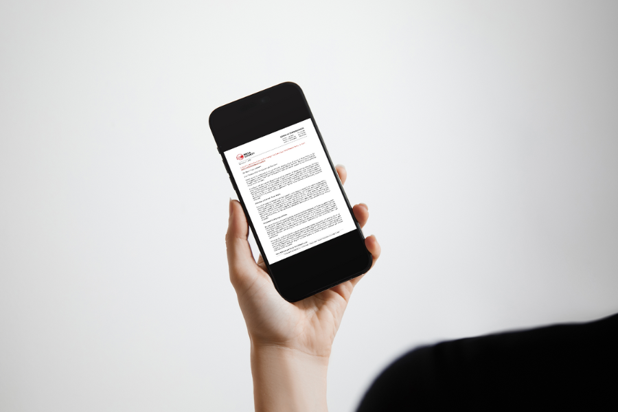 Hand holding smart phone displaying a letter. 