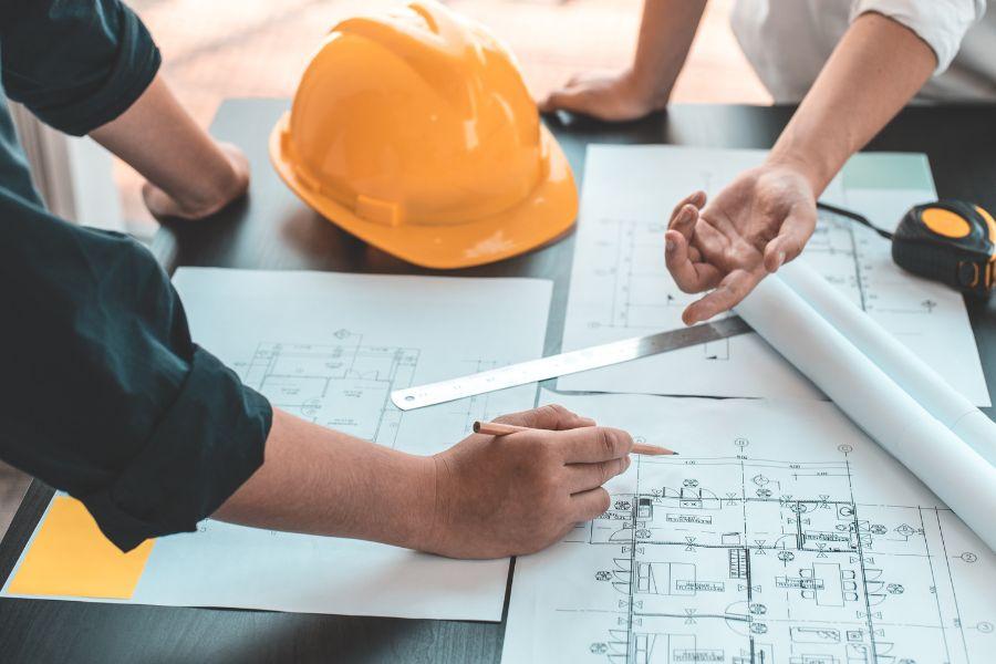Two hands pointing to design for construction project. 