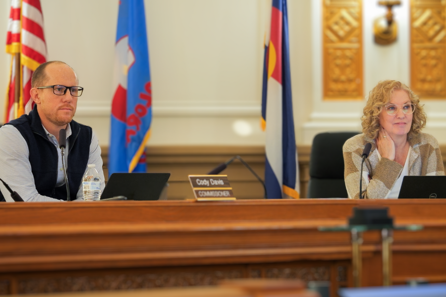 Mesa County Commissioners Cody Davis and Janet Rowland sit at the dias 