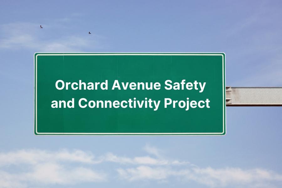 Green street sign with white text reading, "Orchard Avenue Safety and Connectivity Project."