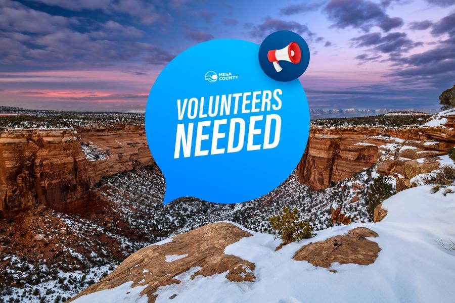 View from the National Monument in Mesa County, CO, at sunset with blue and white speech bubble and red mega phone element with white text reading, "Volunteers needed," with the white Mesa County logo on top. 