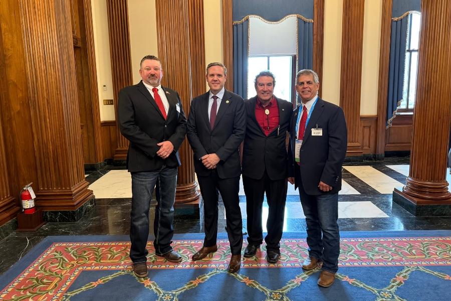 Four men smiling for a group photo. 