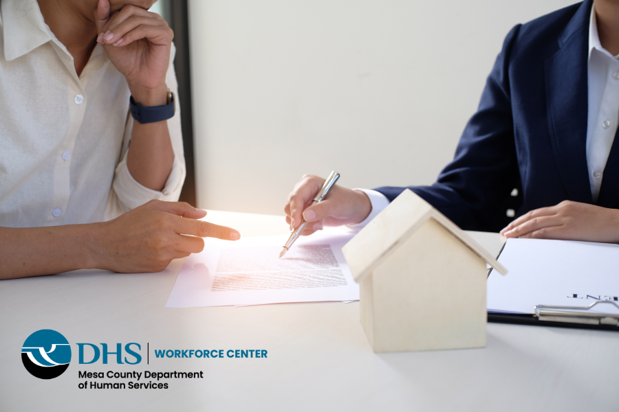 Two people signing a document at a table with a diagram of a house.