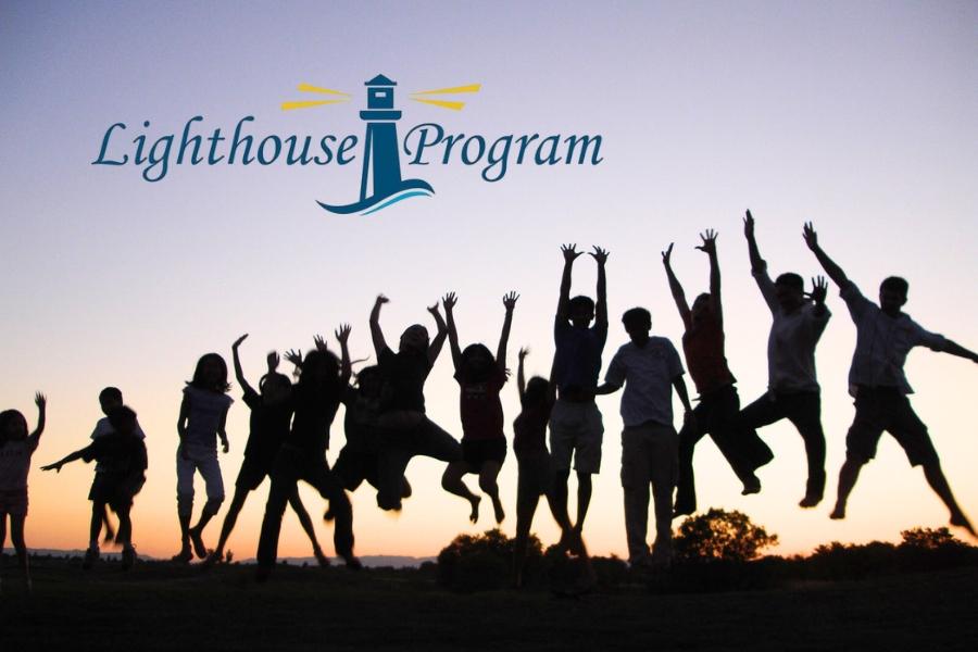 Silhouette of group of children jumping with their hands up at sunset with the blue and yellow Lighthouse Program logo above. 