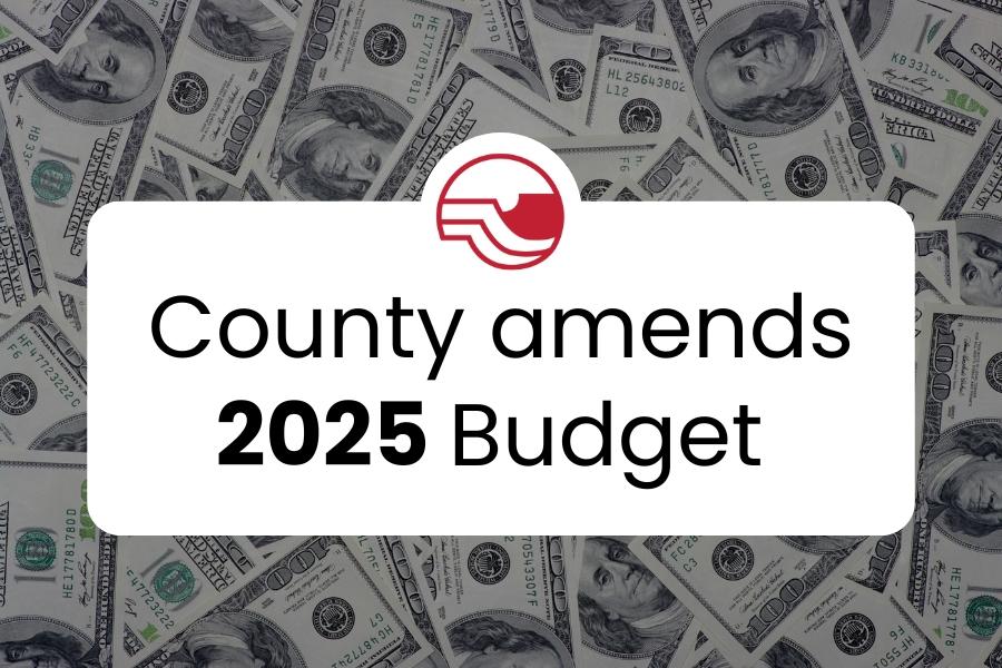 $100 bills with black text reading, County amends 2025 Budget. 
