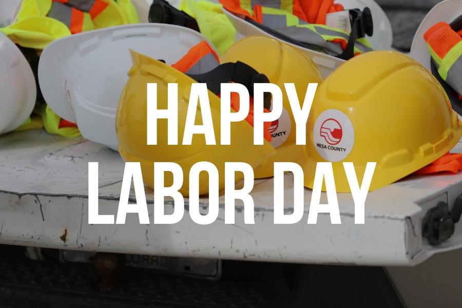 Construction hats with the Mesa County logo on them and white text reading, HAPPY LABOR DAY.