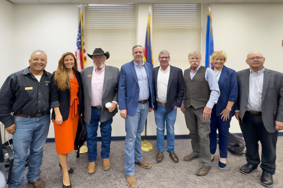 Eight people smiling in professional clothing. 