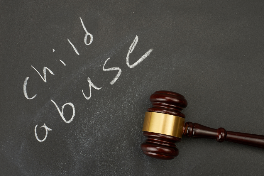 Child Abuse written on a chalkboard with judge's gavel