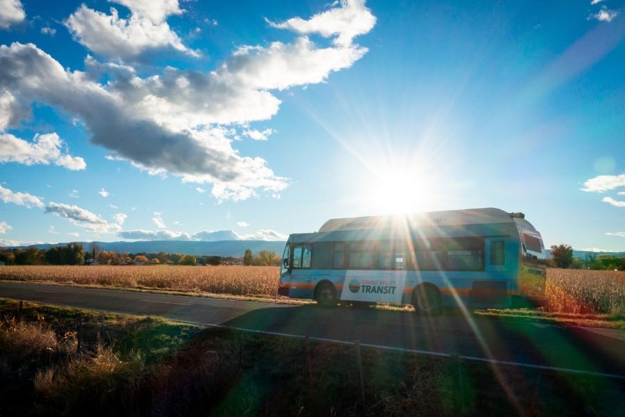 A Grand Valley Transit bus driving down a rural road. 