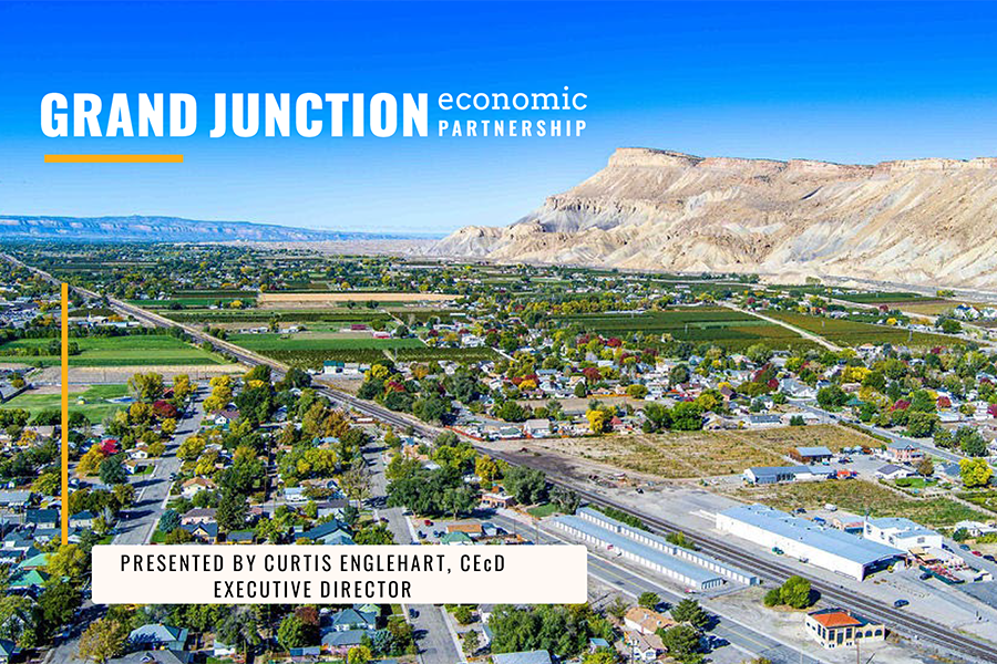 An aerial view of the Grand Valley with neighborhoods, farmland and Mount Garfield in the background, overlaid with text reading “Grand Junction Economic Partnership” and “Presented by Curtis Englehart, CEcD, Executive Director.”