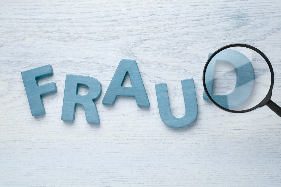 Letters spelling fraud with "D" under a microscope on white background