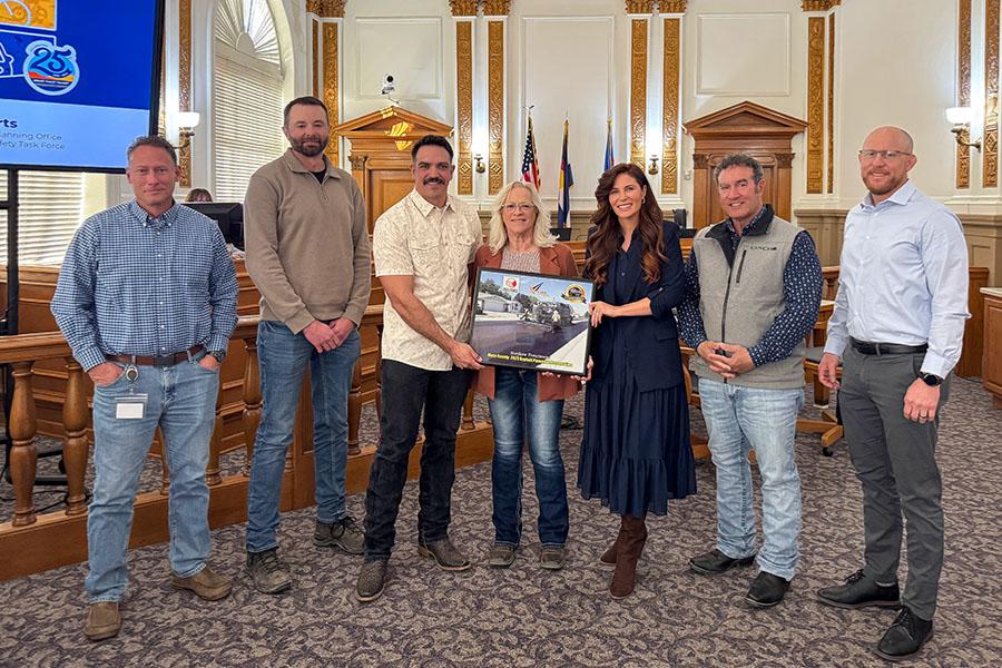 Mesa County Engineering team members stand with the Mesa County Commissioners holding a statewide asphalt pavement award plaque.