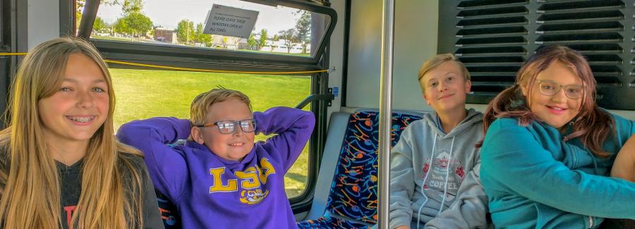 Four kids riding a bus